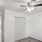a room with a ceiling fan and white doors